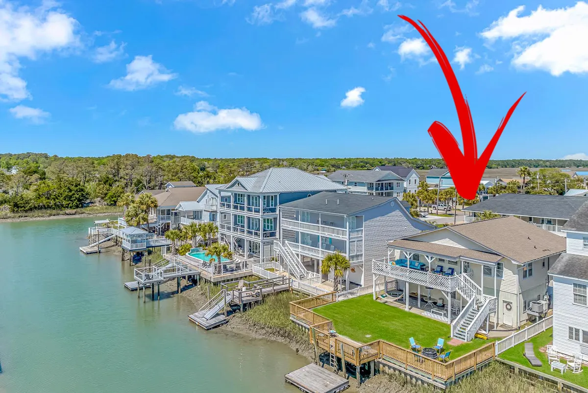 A vibrant waterfront property scene featuring a pool, green lawn, deck seating, and the waterway in the background. The image suggests an inviting atmosphere for outdoor dining, swimming, boating, and enjoying sunsets with loved ones.